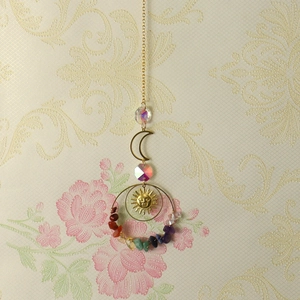 Detail of sun catcher featuring crescent moon, sun face and colorful crushed crystals