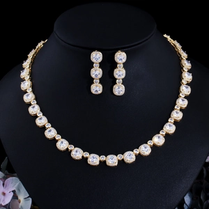 Elegant gold zircon necklace and earrings set displayed on a professional jewelry bust