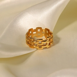 Detailed close-up of 18k gold mesh watch band style ring on white silk fabric