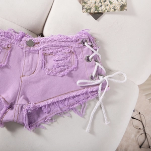 Dettaglio degli shorts in denim viola a vita alta con stringhe laterali e bordi sfrangiati