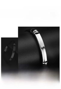 Detail of polished stainless steel plate on black braided cord bracelet for custom engraving