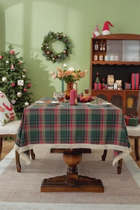 Dettaglio della tovaglia natalizia a quadri rossi e verdi con frange di nappe beige