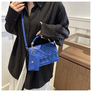 Blue tote bag with embossed floral texture and matching mini coin purse accessory