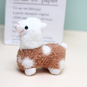 Dettaglio di un piccolo peluche di alpaca con pelliccia riccia e occhi carini