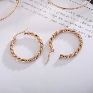 Minimalist gold-tone twisted hoop earrings featuring a stylish spiral textured design