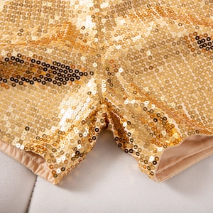 Nahaufnahme glitzernder goldener Pailletten auf High-Waist-Shorts mit dichter Metallstruktur