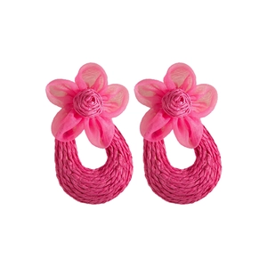 Detail of handmade woven raffia earrings with vibrant pink mesh flower design