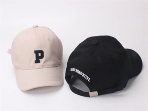 Detail view of cotton baseball caps in beige and black with letter P embroidery