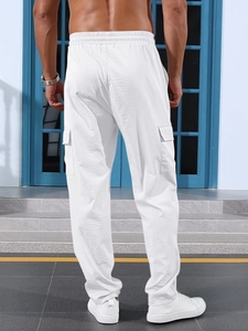 Close-up back view of white loose-fit cargo pants showing rear flap pocket and fabric texture