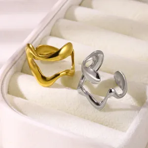 Close-up of gold and silver irregular wave rings in white velvet jewelry display box