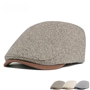 Detail of herringbone pattern fabric and brown brim on this vintage style flat cap for men