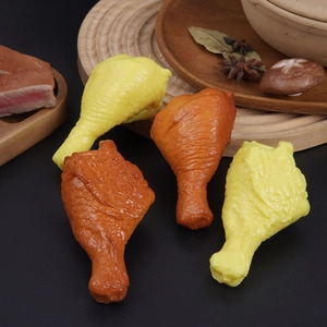 Lifelike PVC chicken drumstick food models displayed on a rustic kitchen set