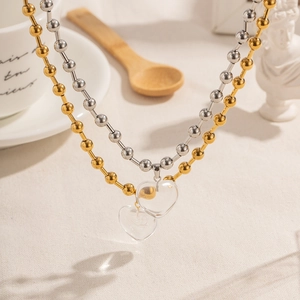 Detailed view of titanium steel beaded necklace with a clear heart pendant in a cozy setting