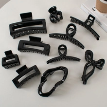 Flat lay of 10-piece black glossy hair claw clip set in various wave and geometric shapes