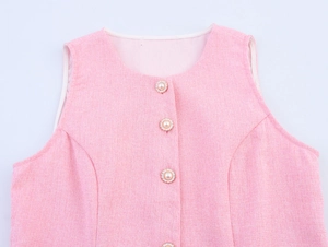 Nahaufnahme der rosa Tweed-Weste mit eleganten Perlenknöpfen und gewebter Textur