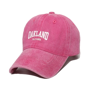 Close-up of pink washed cotton baseball cap with white Oakland California printing