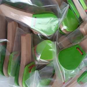 Detail von einzeln verpackten Holz-Kastagnetten mit grünen Platten im Polybeutel