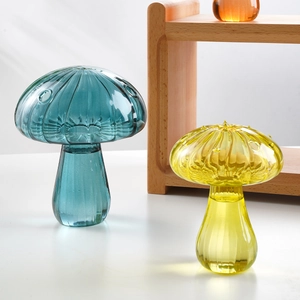 Detail of mushroom glass vases in teal and yellow with textured ribbed patterns