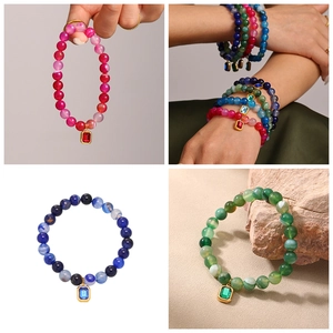 Detail view of beaded bracelets with colorful agate stones and gold-edged square pendants
