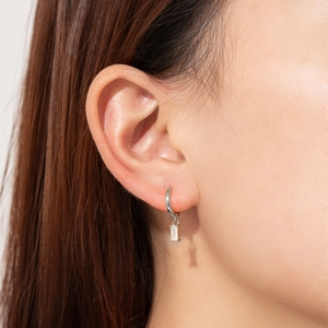 Close-up of S925 silver hoop earrings featuring a rectangular baguette-cut zircon drop
