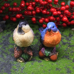Statuine di uccelli realistici in resina su pigne e ghiande per decorazioni