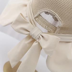 Élégant chapeau de soleil tressé beige avec un grand nœud et protection UV pour la plage