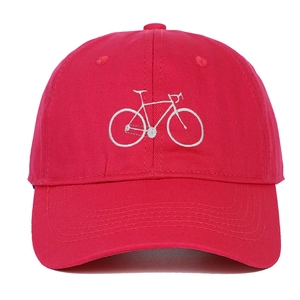 Detailed close-up of a red cotton baseball cap with white embroidered bicycle logo