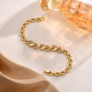 Detailaufnahme vom goldenen Weizenblatt-Armband mit Zirkonia auf Seide