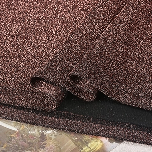 Gros plan sur la texture du tissu à paillettes bronze avec reflets métalliques
