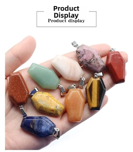 Detailed view of coffin shaped natural stone pendants in various colors held in hand