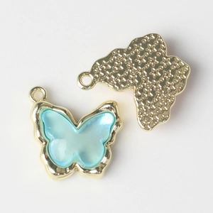 Close-up of sky blue resin butterfly charm with gold alloy edges for DIY jewelry making