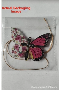 Detailed view of dachshund butterfly acrylic hanging ornament in clear plastic packaging
