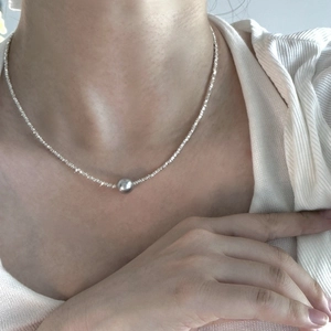 Minimalist S925 sterling silver pearl necklace worn by a model on a neutral background