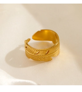 Detailed close-up of feather textured adjustable golden ring on white silk background
