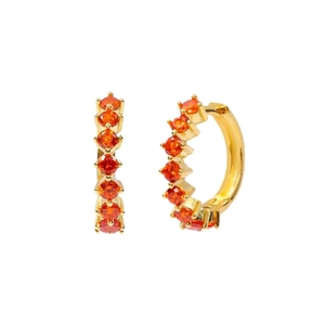 Macro detail of gold-plated hoop earrings featuring seven vibrant orange round-cut zircons