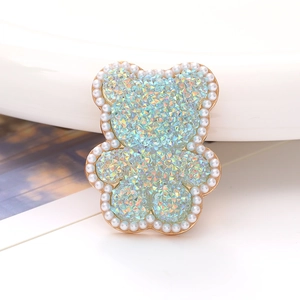 Macro shot of light blue acrylic bear charm with colorful rhinestones and pearls