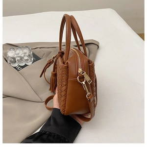 Detail of handcrafted brown woven leather bag showing side texture and structure