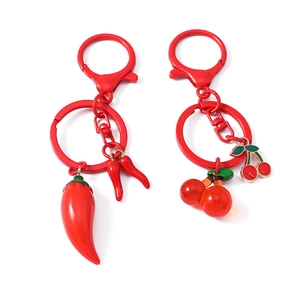 Creative resin red cherry and chili food pendants on metal keyrings over white background