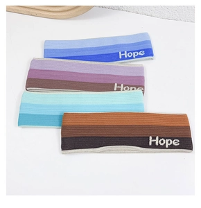 Close-up of four gradient sports headbands with Hope embroidery on knitted fabric