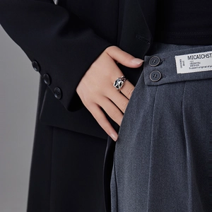 Macro detail of silver lava texture ring with black gemstone on model with suit