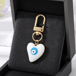 Macro shot of heart-shaped evil eye pendant with gold clasp on black velvet jewelry box