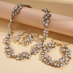Parure de bijoux vintage dorée avec perles et strass sur un parchemin beige