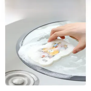 Close-up of printed cartoon sponge producing rich dense foam for cleaning kitchenware