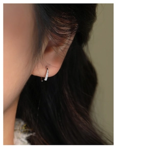 Close-up of elegant S925 sterling silver hoop earrings with sparkling zircon on earlobe