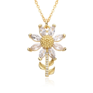 Close-up of golden sunflower pendant with sparkling marquise zircon petals and crystal chain