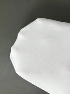 Macro detail of high-quality white knit fabric texture showing fine stitching and soft material