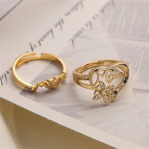 Macro detail of gold Mom heart ring with butterfly and adjustable heartbeat ring set