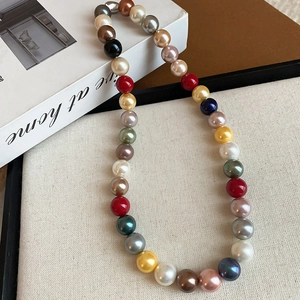 Colorful faux pearl necklace on elegant fabric background with light lifestyle aesthetic