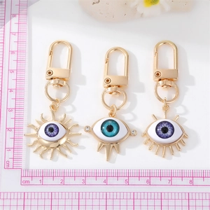 Detailed size comparison of three gold-plated Evil Eye keychains with blue resin accents