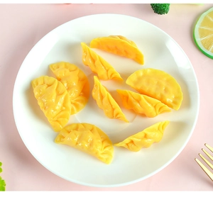 Gedetailleerd bovenaanzicht van realistische gele dumplingmodellen op een wit bord